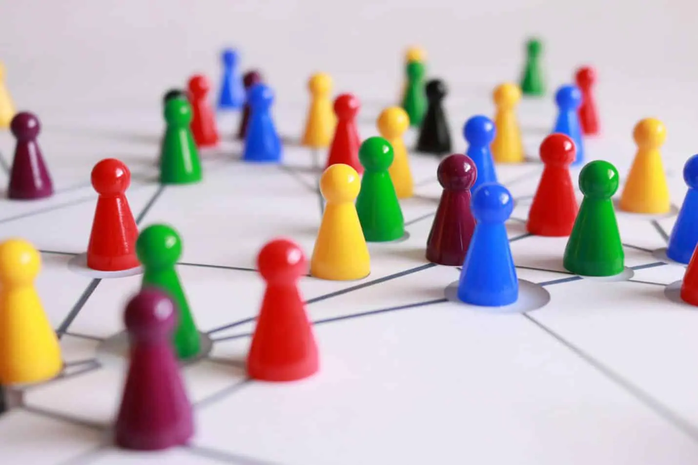 Diverse colorful game pieces connected on a network board for collaboration
