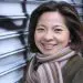 Portrait of a smiling Asian woman in a brown striped scarf