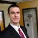 Smiling man in suit outside Texas A&M Geology Geophysics Advising Office