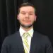 Young professional man in dark suit, white shirt, yellow striped tie