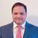 Professional portrait of a smiling businessman in blue suit and pink tie