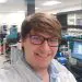 Happy scientist wearing glasses and lab coat in a modern research laboratory