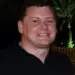 Smiling man in black shirt, looking at camera. Headshot, professional profile
