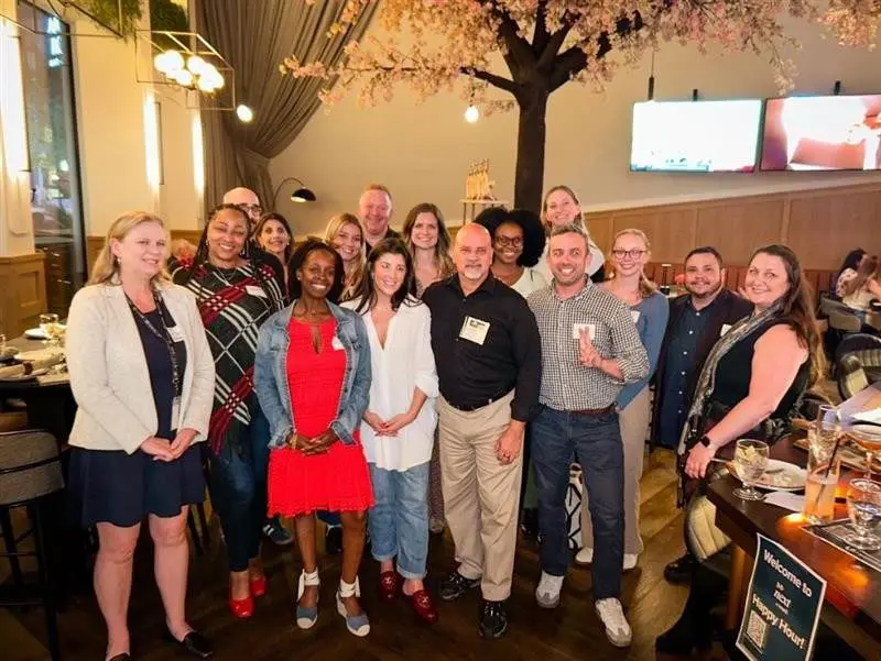 Smiling diverse group enjoys happy hour event, networking in a lively restaurant