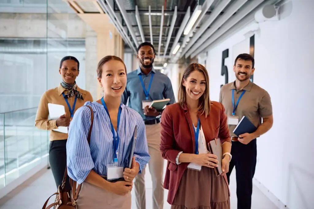 Diverse group of smiling business professionals with ID badges in a modern office