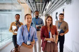 Diverse group of smiling business professionals with ID badges in a modern office