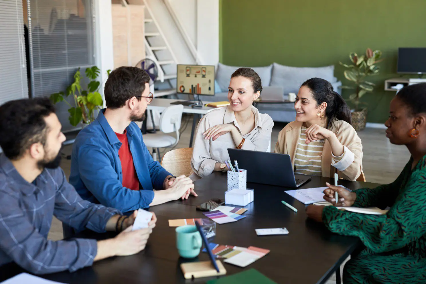 Diverse professionals collaborating in modern office meeting, discussing strategies and new ideas