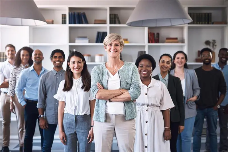 Diverse business professionals smiling at camera in modern office setting