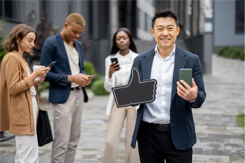 Diverse business team with smartphones, one man gives a thumbs up sign